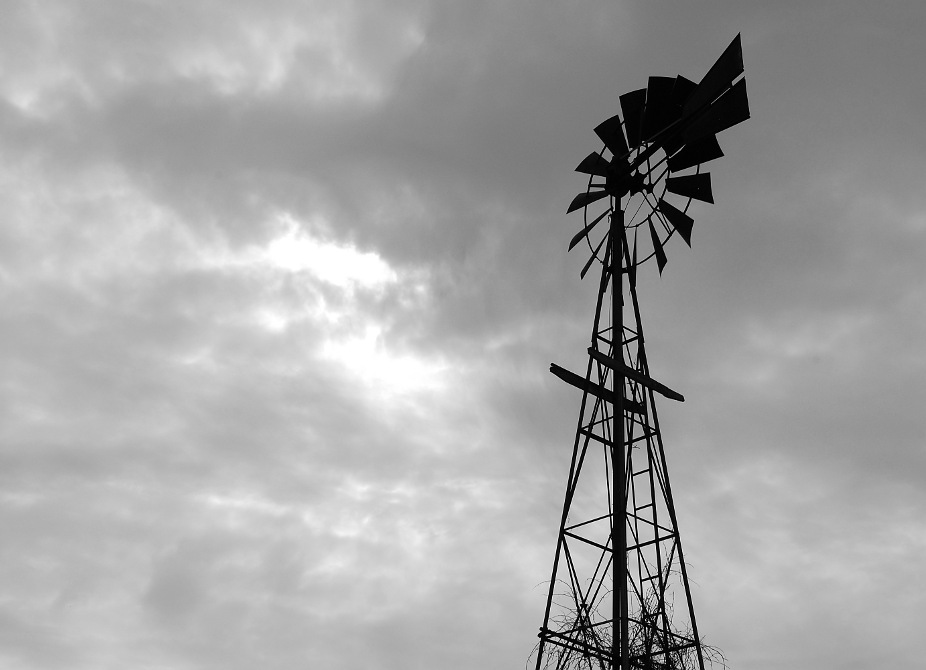 silhouette of farm windmill in a cloudy sky