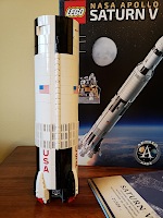 Lego pieces from 5 bags forming the first stage of a Saturn V rocket