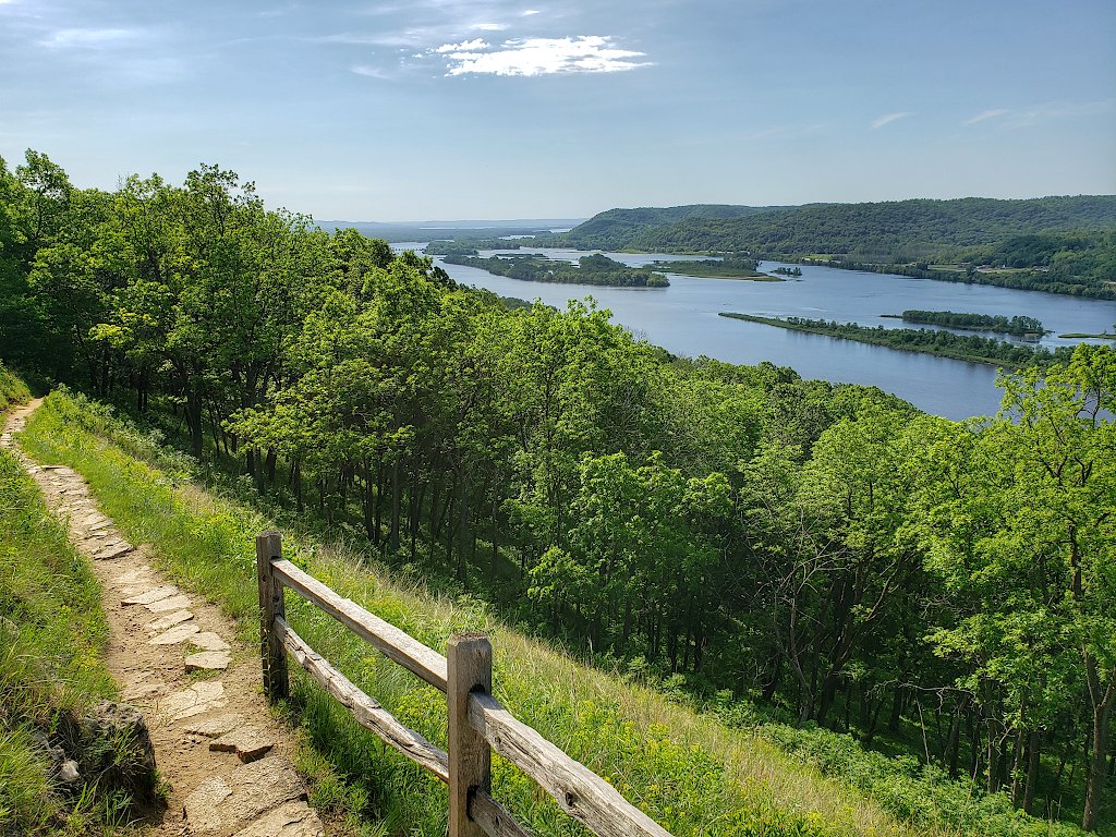 Hiking trail leading down the side of a bluff with the Mississippi River in the background