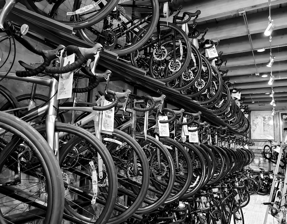 Looking down a row of bicycles, on display along a wall.